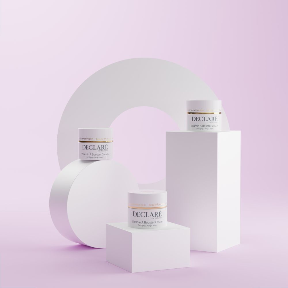 Drei weiße Podeste mit DECLARÉ Vitamin A Booster Cream. Hintergrund mit weißem Kreis und Formen.