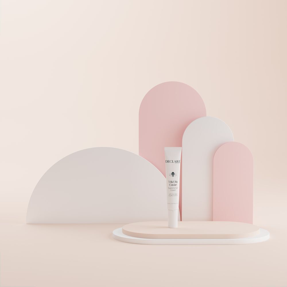 Tube 'Olu'Olu Caviar Supreme Eye Cream auf Podest. Hintergrund mit Formen. DECLARÉ-Logo sichtbar.