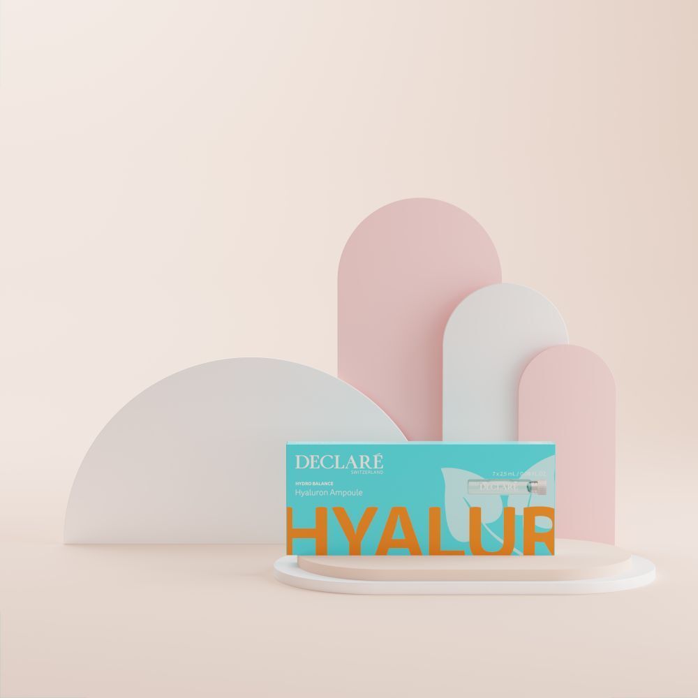 Türkisblaue Schachtel mit DECLARÉ-Logo und Produktnamen. Auf Podest platziert. Hintergrund mit rosa und weißen Formen.