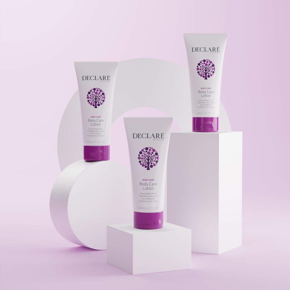 Drei weiße Tuben mit lila Verschlüssen. DECLARÉ-Logo und Produktbezeichnung Body Care Lotion. Auf Podesten.