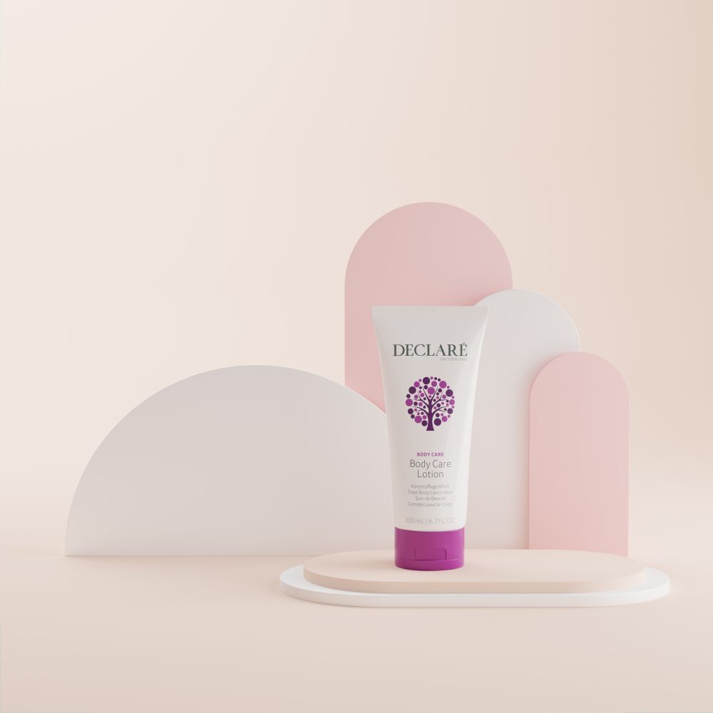 Weiße Tube mit lila Verschluss. DECLARÉ-Logo und Produktbezeichnung Body Care Lotion. Auf Podest. Hintergrund.