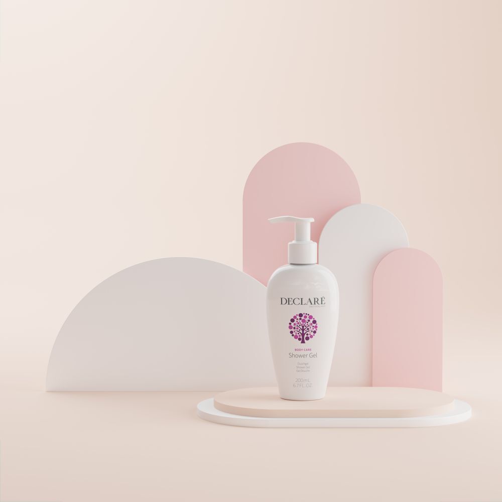 Weiße DECLARÉ-Flasche mit Pumpverschluss auf Podest. Hintergrund: rosa, weiße und rosa Formen. Produkt: Shower Gel.