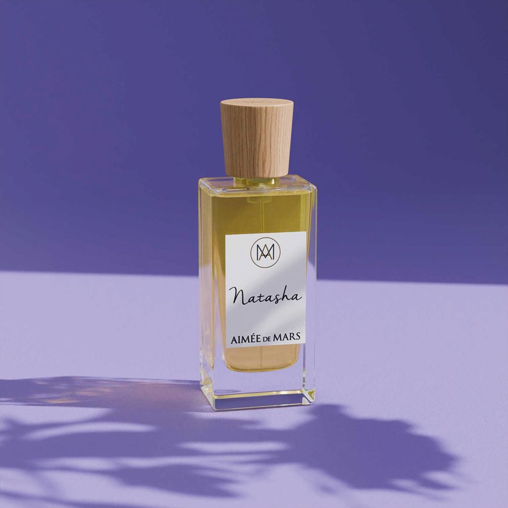 Aimée de Mars Natasha Eau de Parfum Flakon auf lila Hintergrund. Holzverschluss, weißes Etikett.