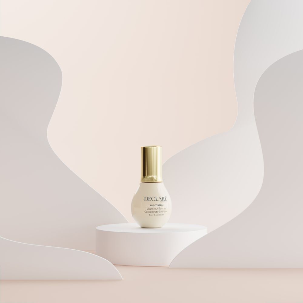 Produkt auf weißem Podest. Hintergrund mit weißen und rosafarbenen Formen. DECLARÉ Age Control Vitamin A Booster.