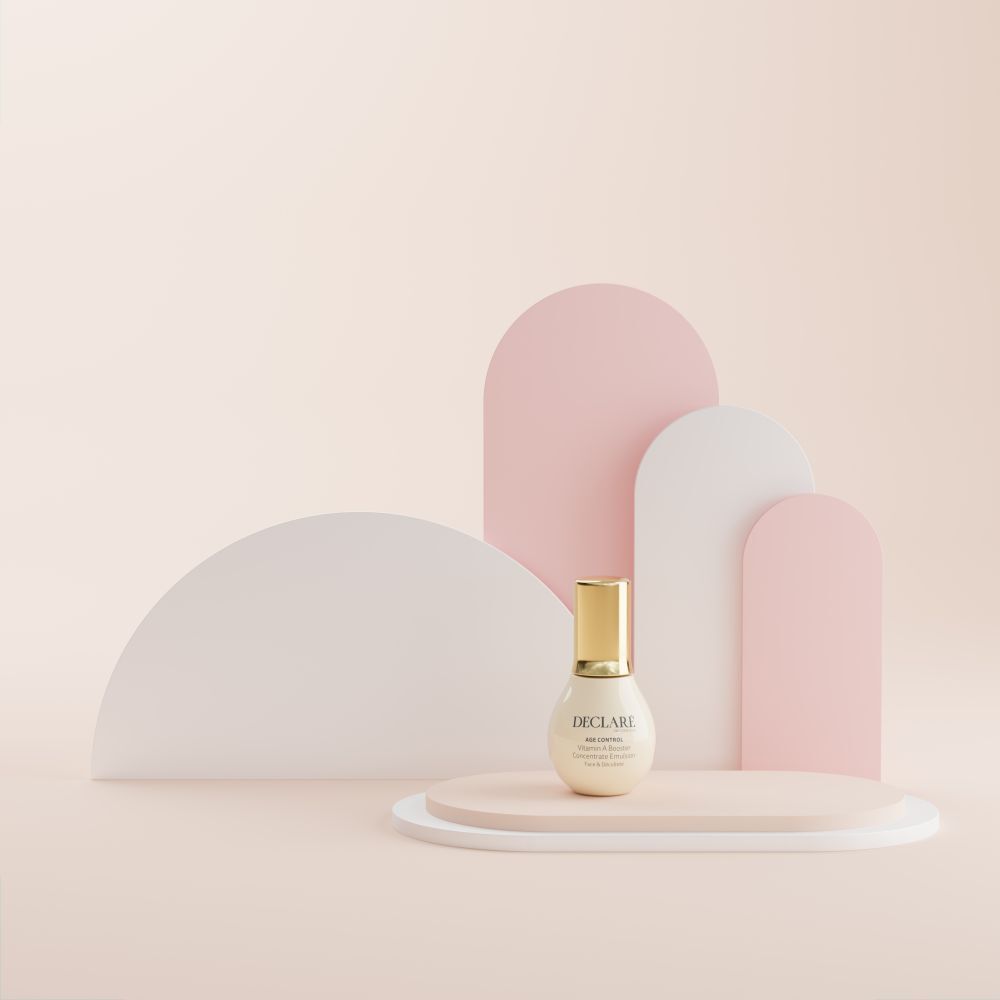 Flasche auf Podest. Hintergrund: rosa, weiß und rosa Formen. DECLARÉ Age Control Vitamin A Booster.
