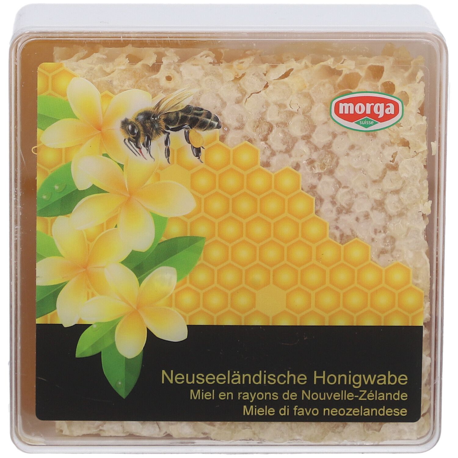 MORGA miel en rayons. Emballage transparent carré avec rayon de miel, fleurs et abeille. Texte: Miel en rayons de Nouvelle-Zélande.