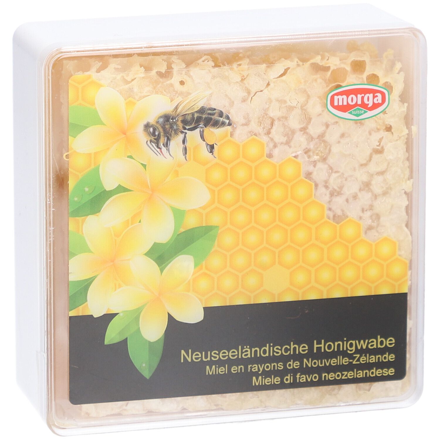 MORGA miel en rayons. Emballage transparent carré avec rayon de miel, fleurs et abeille. Texte: Miel en rayons de Nouvelle-Zélande.