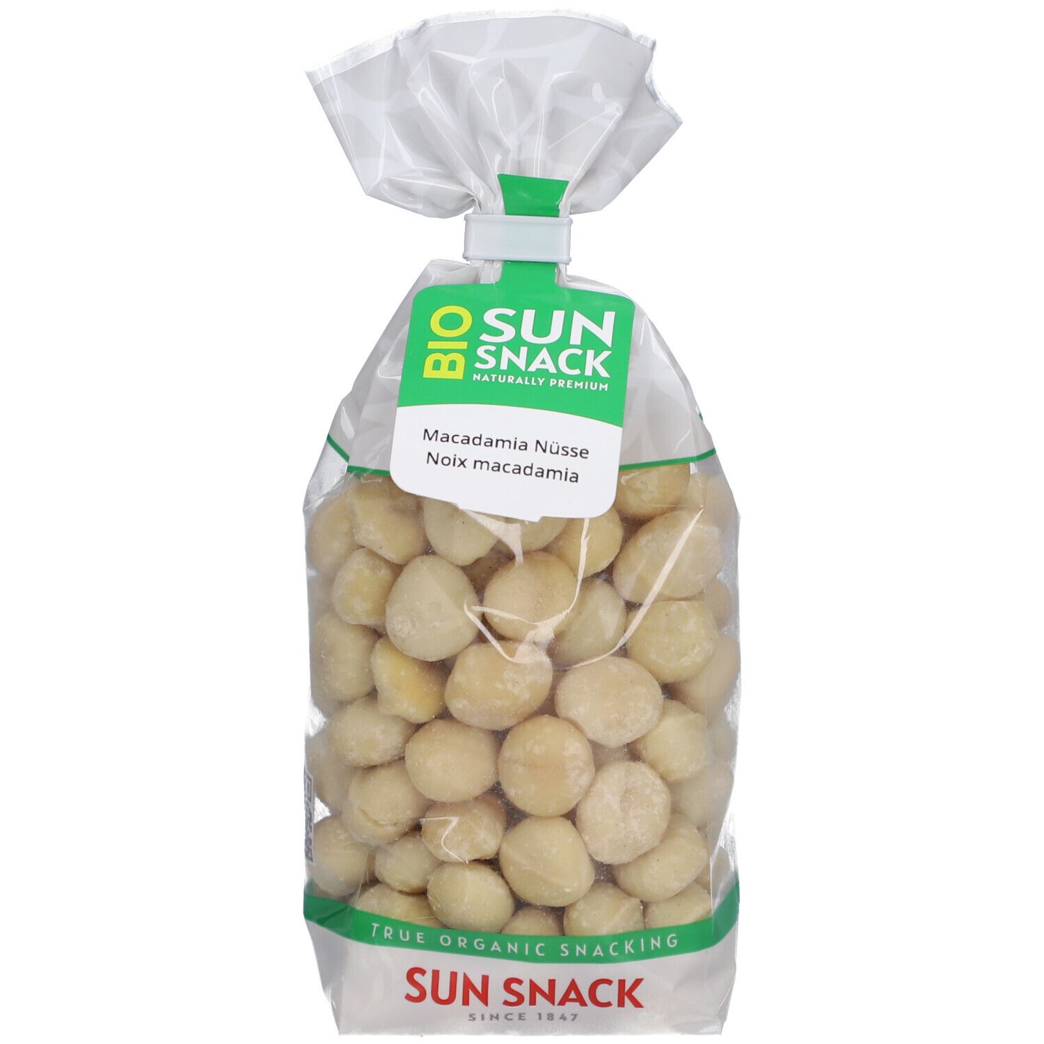 Transparente Tüte mit Bio Macadamia Nüssen. Grün-weißes Etikett mit Produktname und Logo.