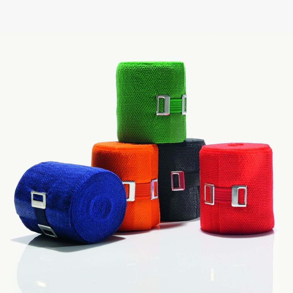 Mehrfarbige Bandagen, gerollt. Blau, grün, orange, schwarz und rot. Metallverschluss. Auf weißem Hintergrund.
