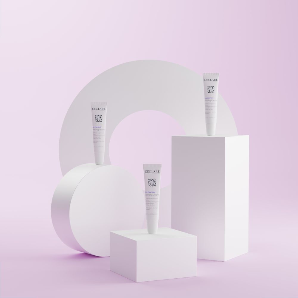 Drei weiße Tuben DECLARÉ Eye Contour Firming Cream auf Podesten. Hintergrund mit Formen.