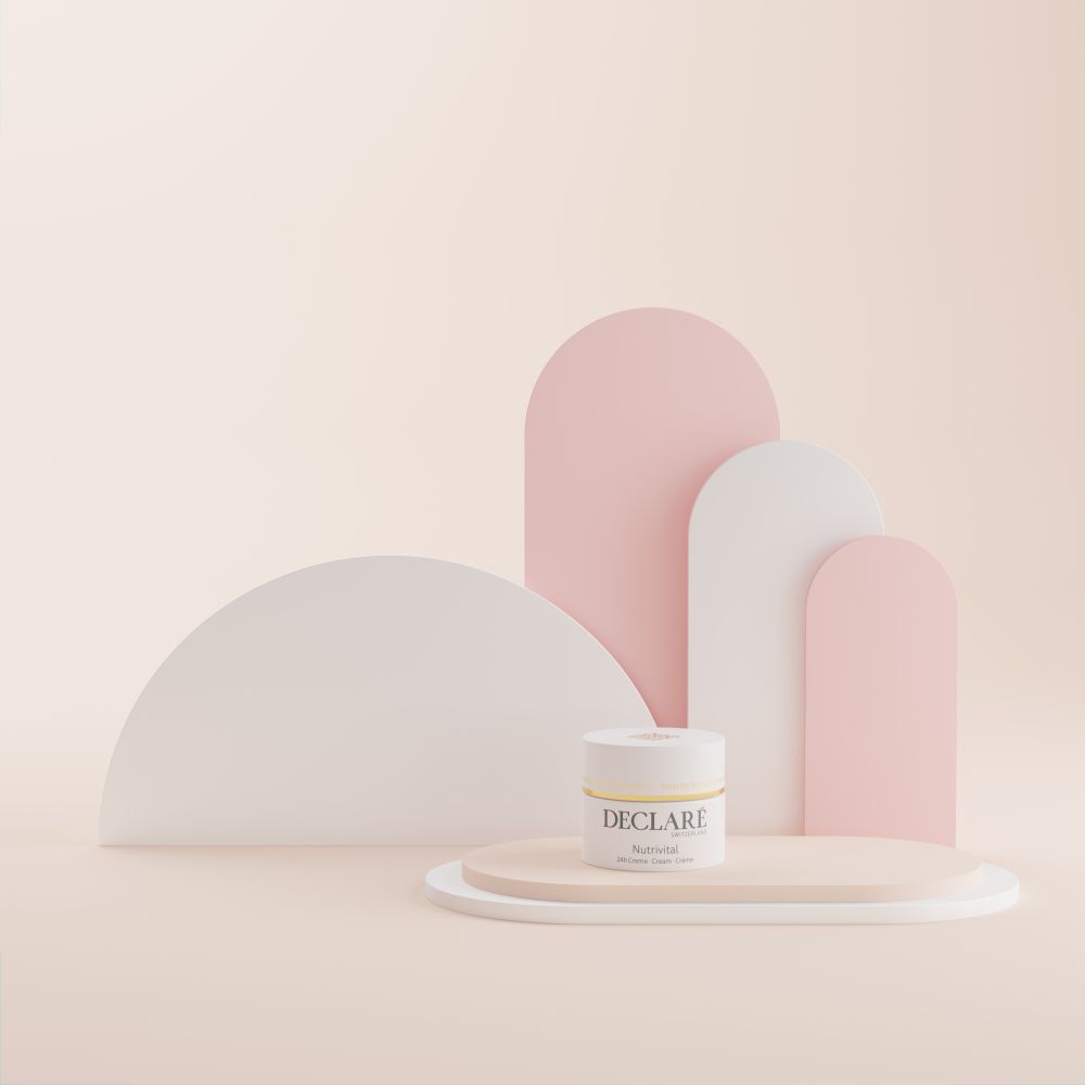 Creme-Tiegel auf einer Plattform. DECLARÉ Nutrivital. Hintergrund mit weißen, rosa Formen.