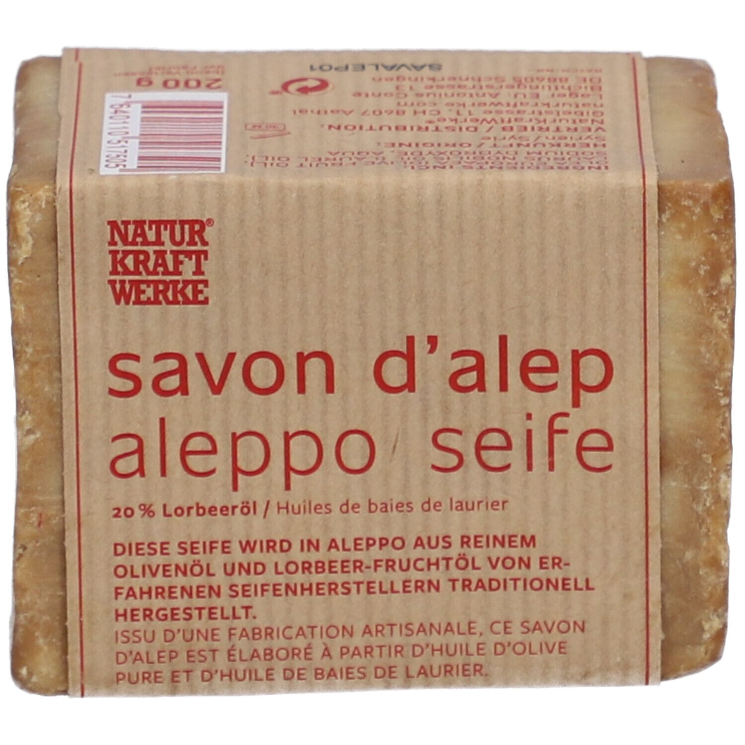 Rechteckige Seife mit Papierbanderole. Aufschrift: savon d'alep aleppo seife, 20% Lorbeeröl. Natur Kraft Werke.