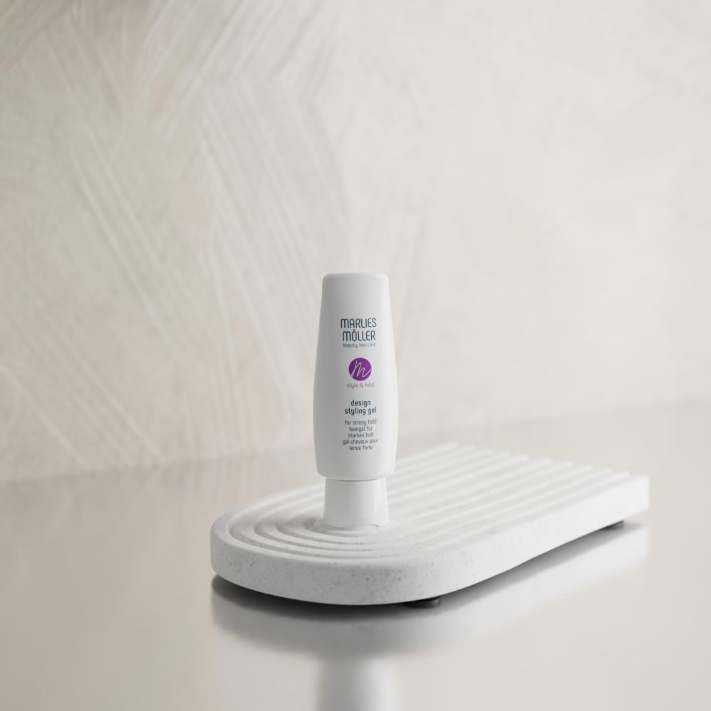 Weißes Design Styling Gel auf weißem Podest. Marke Marlies Möller. Lila Logo.