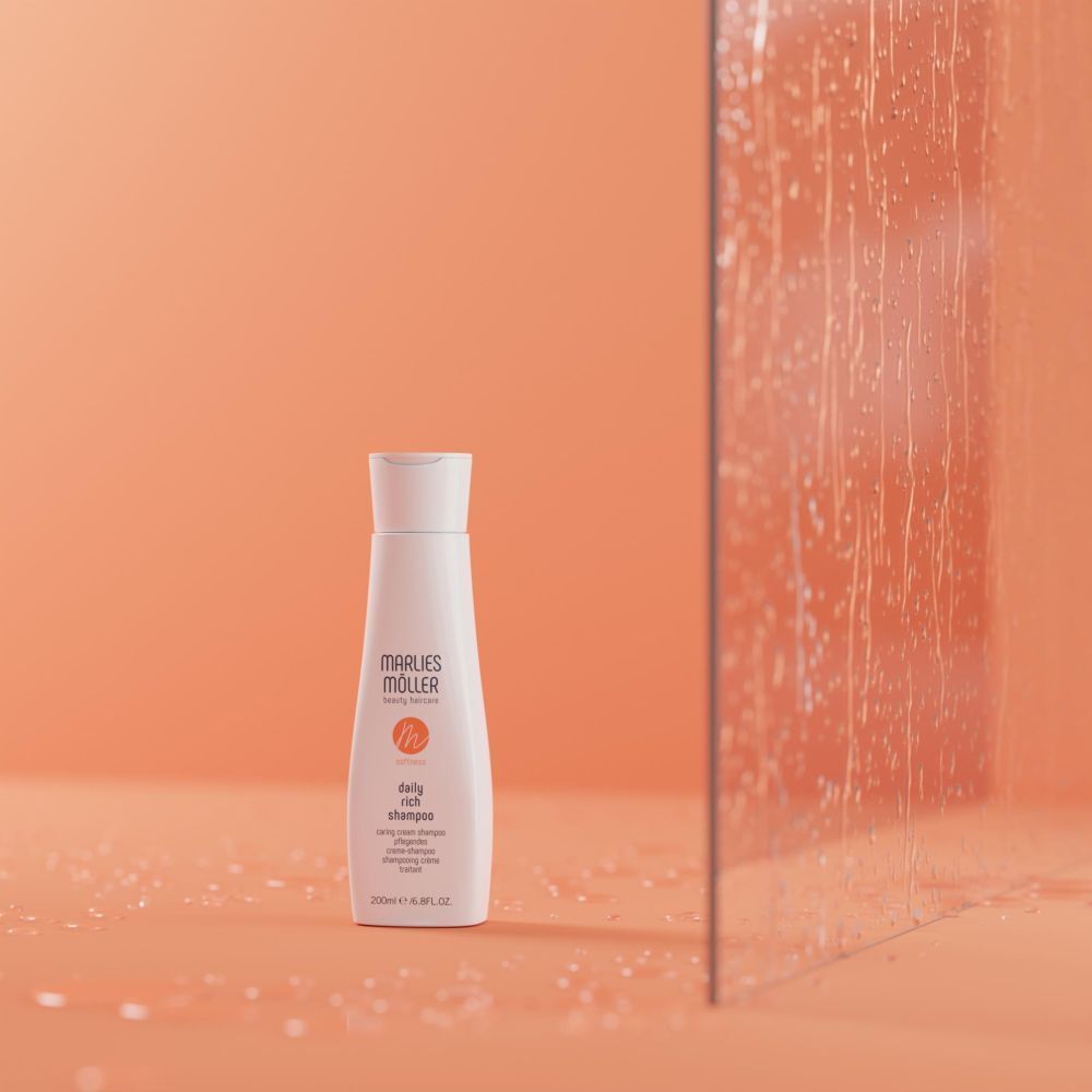 Weiße Flasche Marlies Möller Daily Rich Shampoo vor orangefarbenem Hintergrund. Logo orange. Flasche mit weißem Deckel.