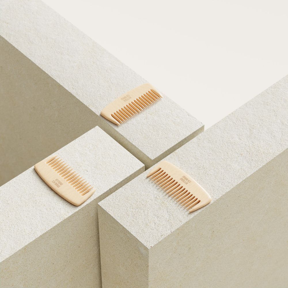 Drei Holzkämme auf weißen Blöcken. Auf jedem Kamm steht "Marlies Möller".