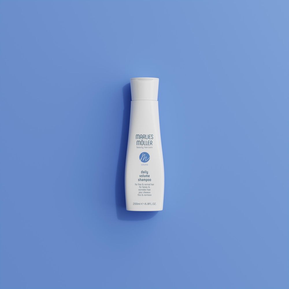 Weiße Shampoo-Flasche auf blauem Hintergrund. Aufschrift: Marlies Möller, Volume Daily Volume Shampoo. 200ml.