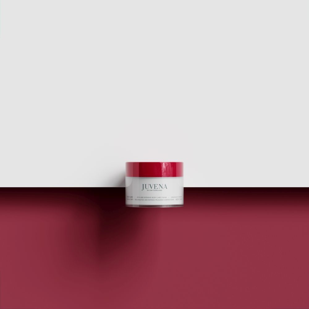 Creme-Dose mit rotem Deckel auf rotem Untergrund. Aufschrift: Juvena. Produktname nicht lesbar.