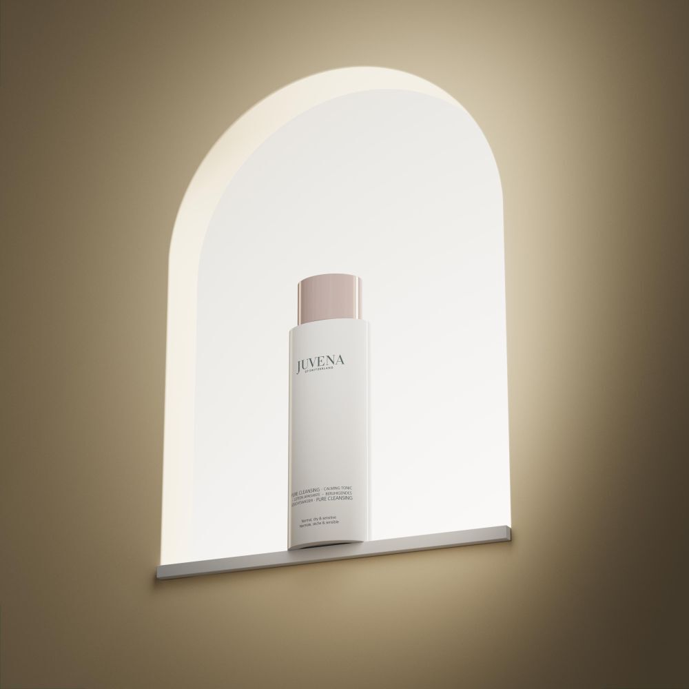 Weißes Fläschchen mit rosafarbenem Deckel. In einer beleuchteten Nische platziert.