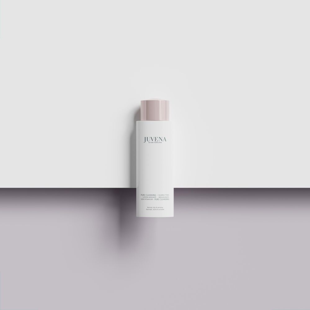 Weißes Fläschchen mit rosafarbenem Deckel. Auf einer weißen Fläche platziert.