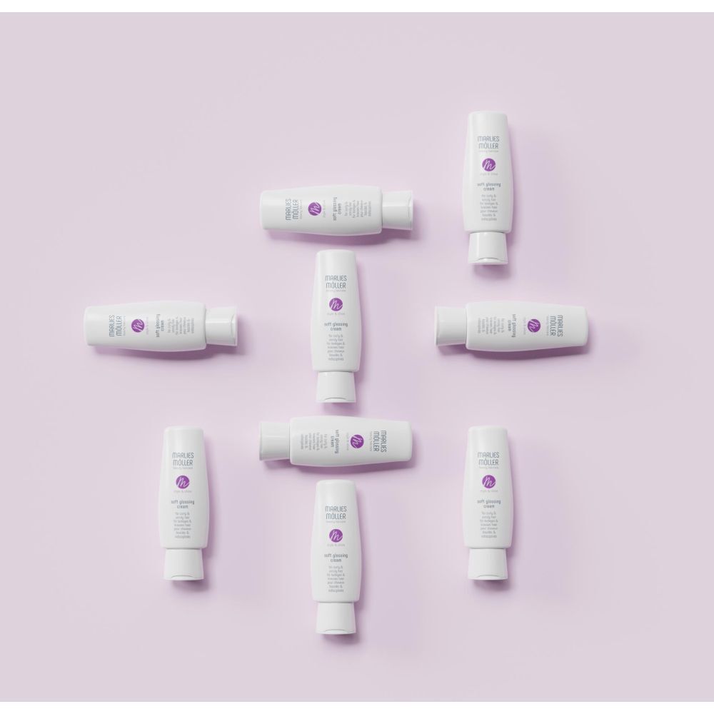 Anordnung von weißen Tuben, Marlies Möller Soft Glossing Cream, auf lila Hintergrund. Neun Tuben.