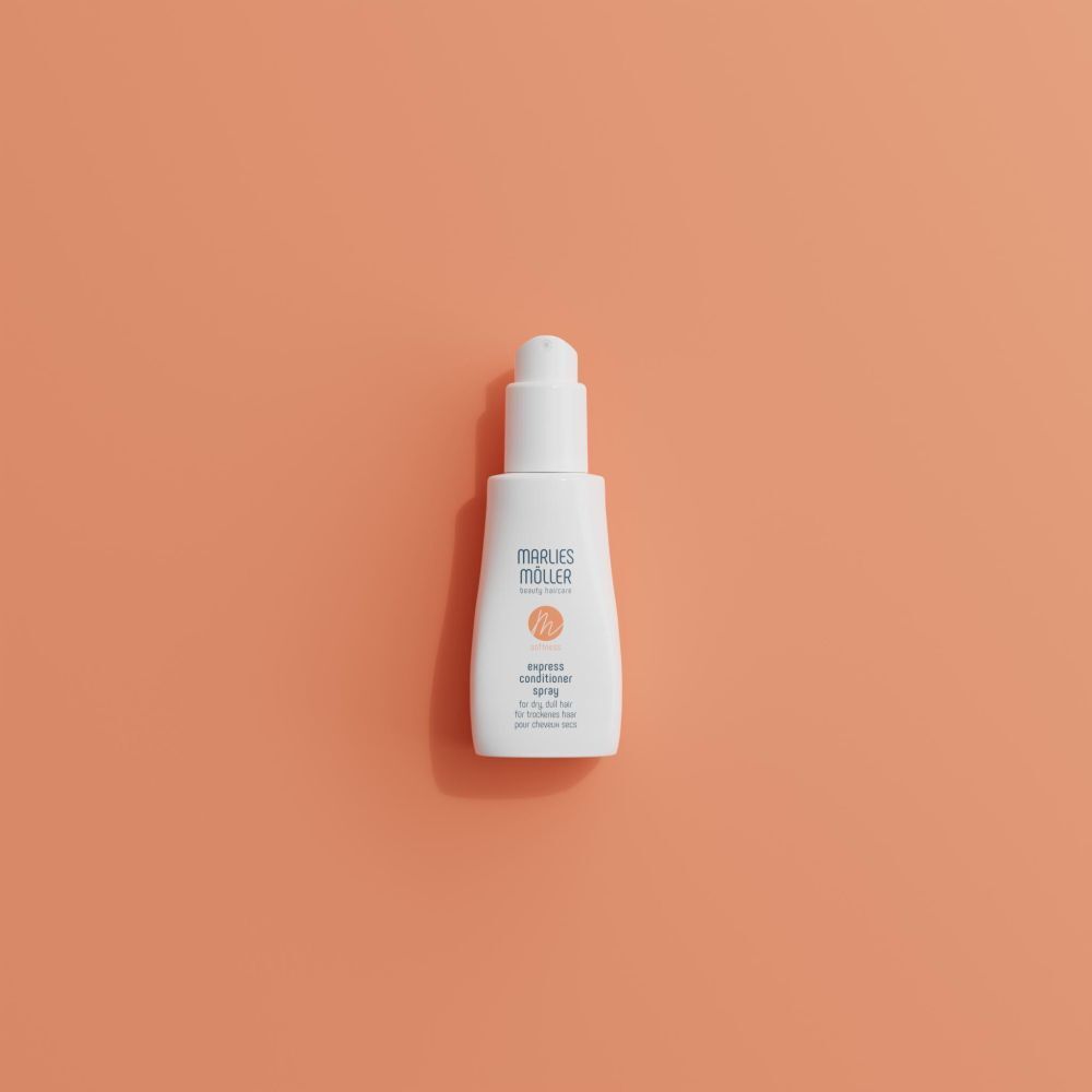 Weiße Flasche vor orangefarbenem Hintergrund. Aufschrift: Marlies Möller, softness, Express Conditioner Spray.