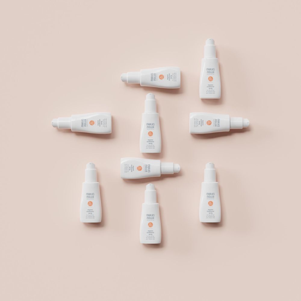 Mehrere weiße Flaschen auf rosa Hintergrund. Aufschrift: Marlies Möller, softness, Express Conditioner Spray.