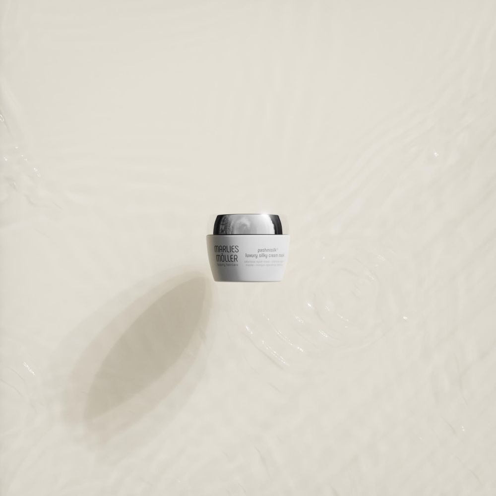 Weißer Tiegel mit silbernem Deckel im Wasser. Produktname: Marlies Möller Pashmisilk Luxury Silky Cream Mask.