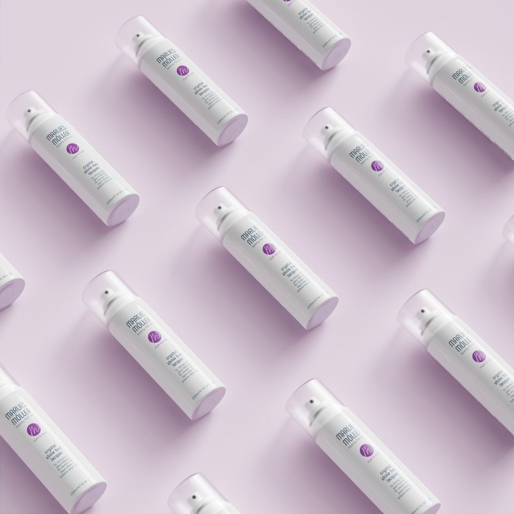 Mehrere weiße Haarsprays von Marlies Möller auf rosa Hintergrund. Aufschrift: Crystal Shine Hair Lacquer.