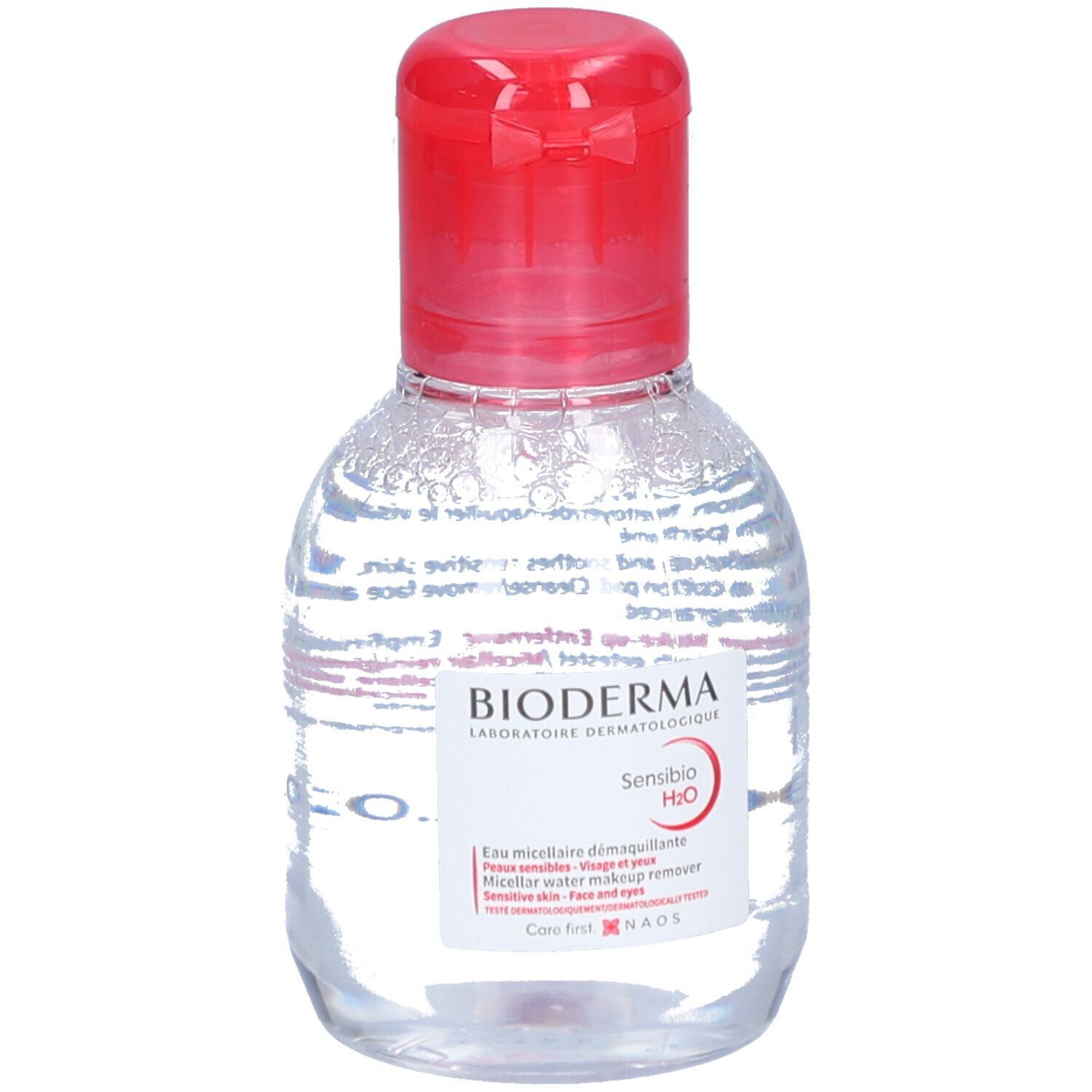 Flacon transparent, bouchon rouge. Étiquette BIODERMA Sensibio H2O. Eau micellaire démaquillante.