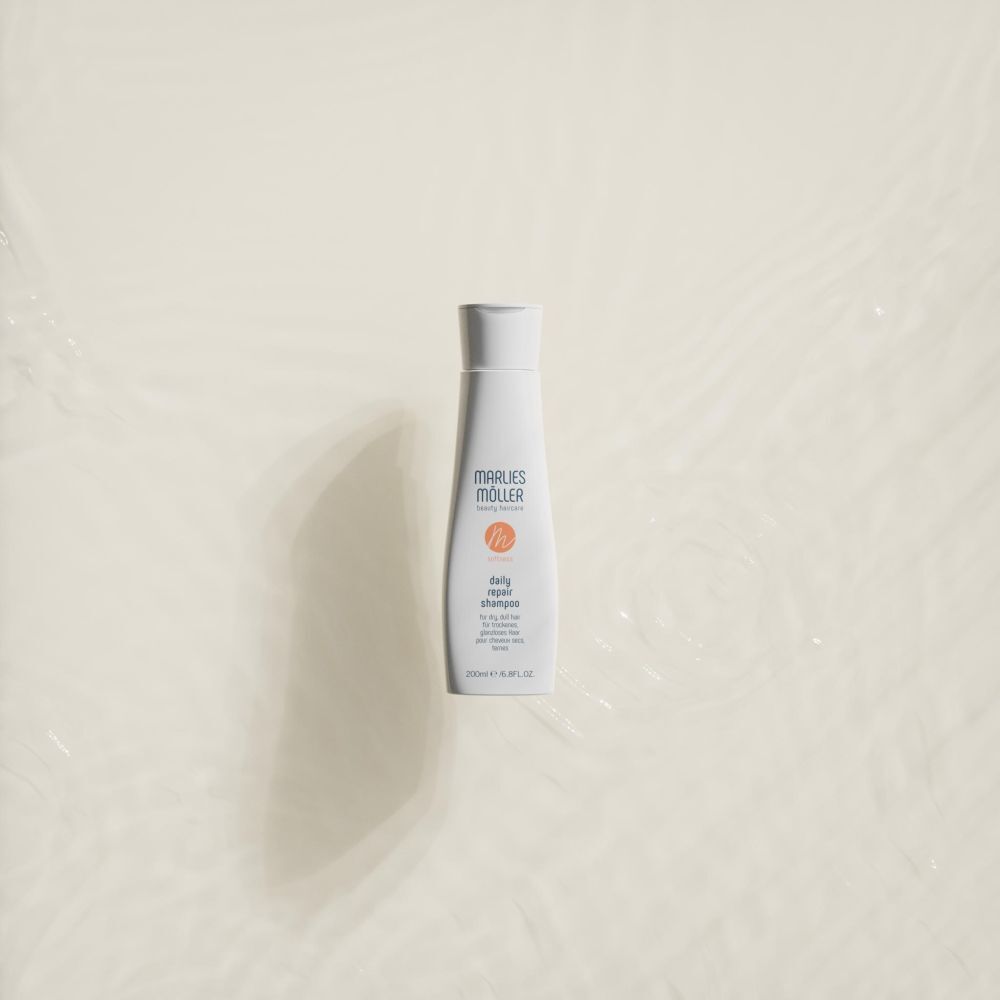 Weiße Shampoo-Flasche auf hellem Hintergrund. Aufschrift: Marlies Müller, daily repair shampoo. 200ml/6.8FL.OZ.