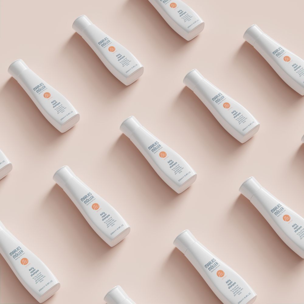 Mehrere weiße Shampoo-Flaschen auf rosa Hintergrund. Aufschrift: Marlies Müller, daily repair shampoo. 200ml/6.8FL.OZ.