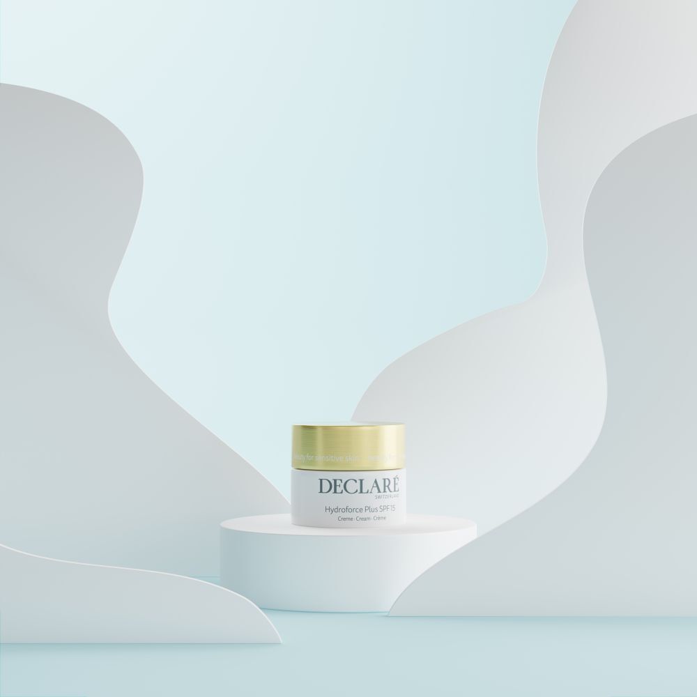 Creme-Tiegel auf Podest. Hintergrund: weiße, geschwungene Formen und hellblauer Farbverlauf. DECLARÉ, Hydroforce Plus SPF15.