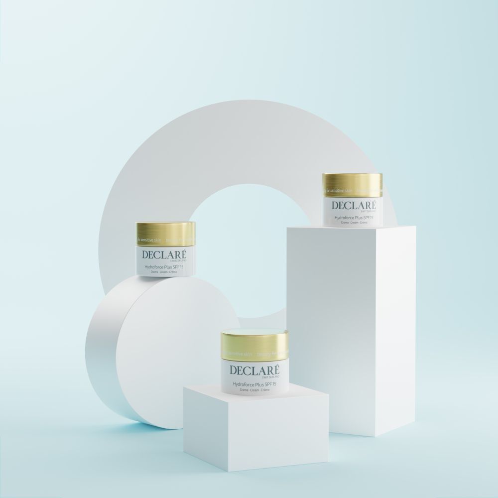 Drei Creme-Tiegel auf Podesten. Hintergrund: weiße Formen und hellblauer Farbverlauf. DECLARÉ, Hydroforce Plus SPF15.