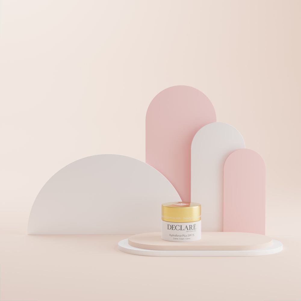 Creme-Tiegel auf Podest. Hintergrund: rosa, weiße und rosa Formen. DECLARÉ, Hydroforce Plus SPF15.
