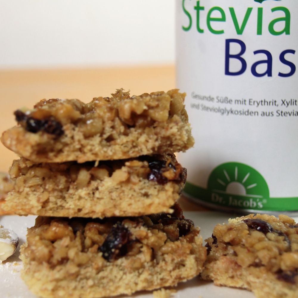 Stapel von Gebäckstücken mit Nüssen und Trockenfrüchten. Dose mit Stevia Base im Hintergrund.