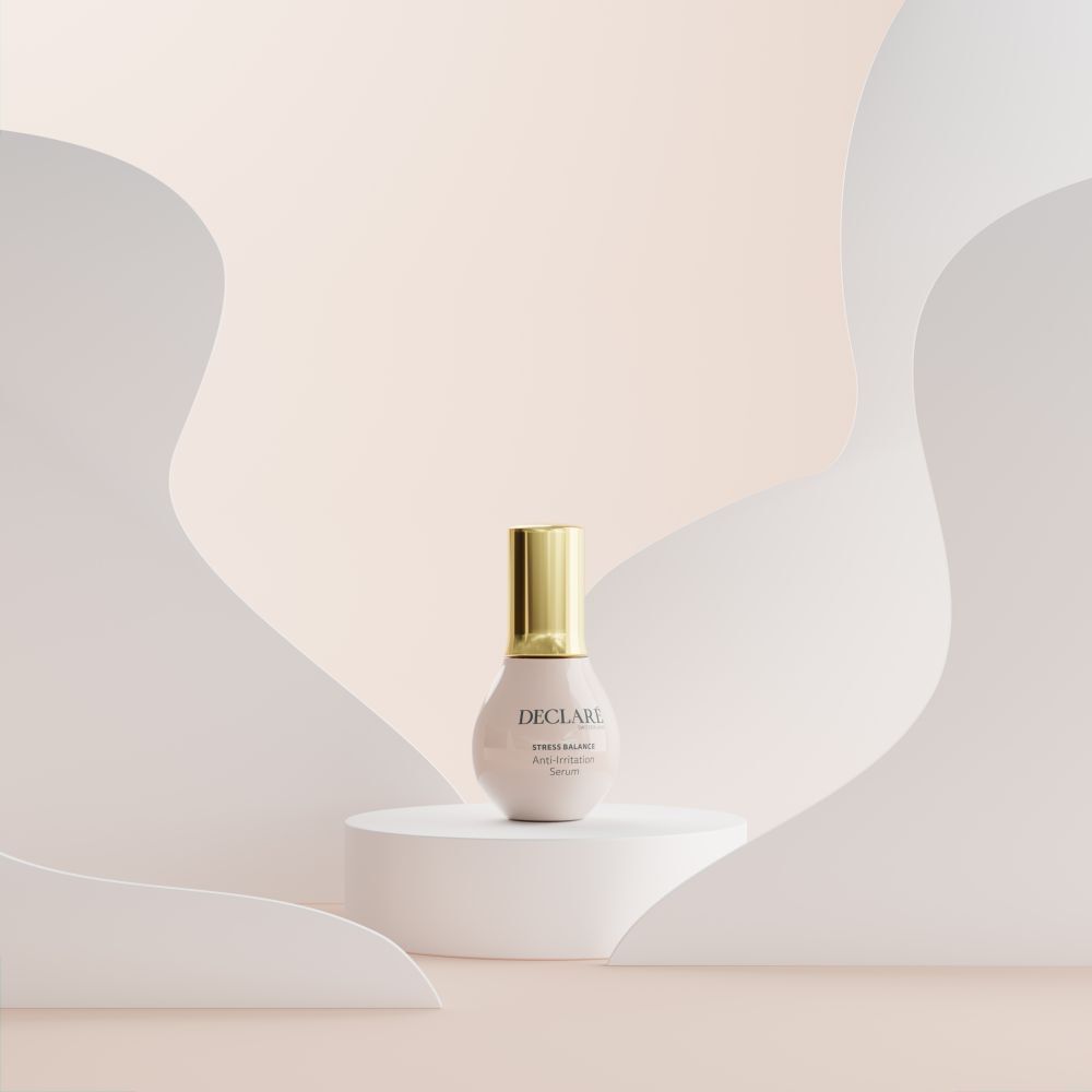 Rosa Serumflasche auf Podest. Goldener Deckel. DECLARÉ Stress Balance Anti-Irritation Serum.