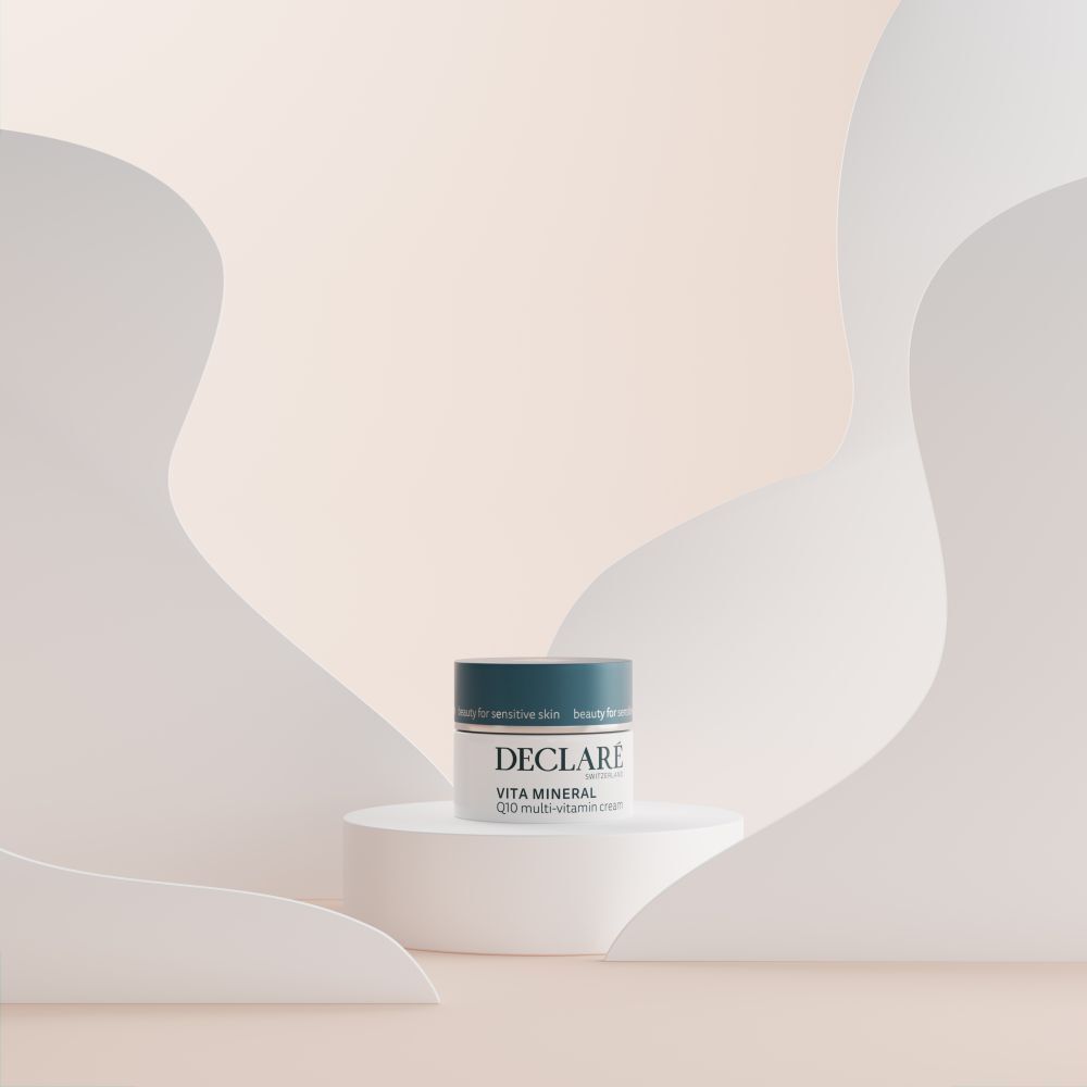 Creme-Tiegel auf Podest. DECLARÉ Vita Mineral Q10 Multi-Vitamin Creme. Hintergrund mit Formen.