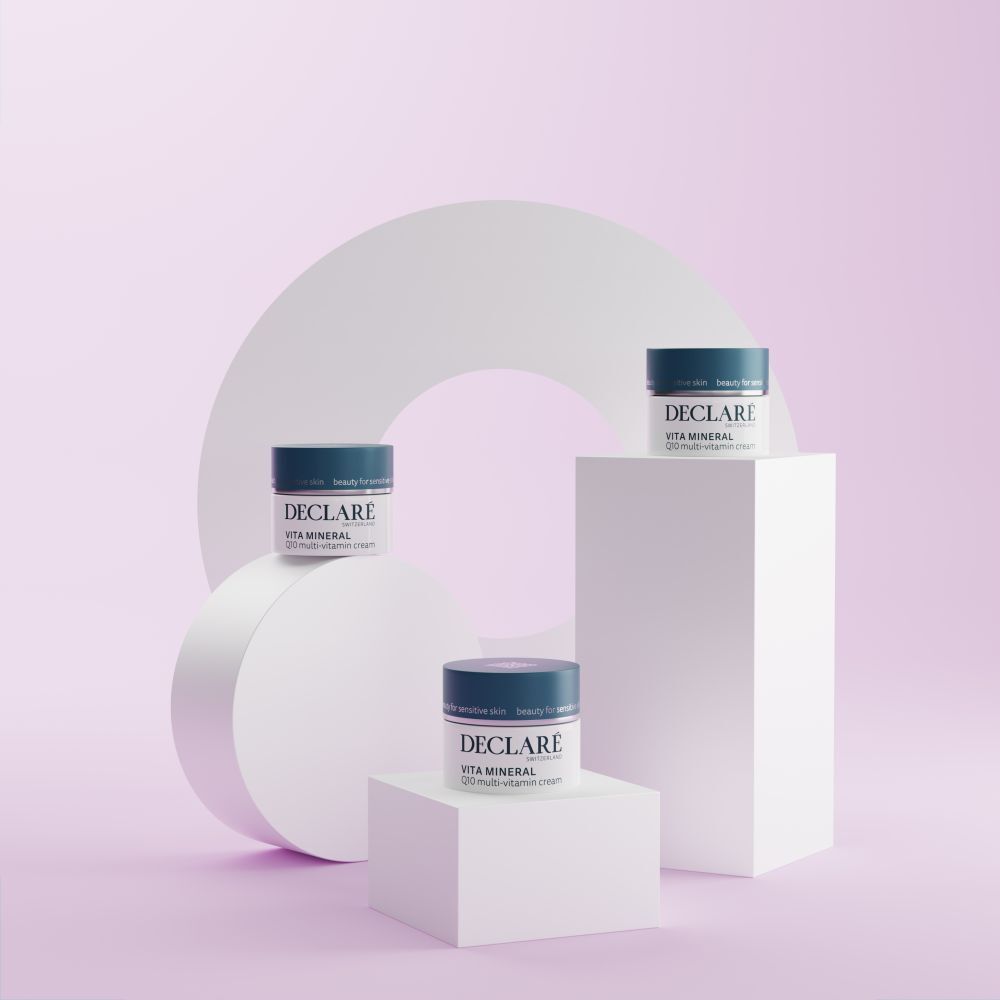 Drei Creme-Tiegel auf Podesten. DECLARÉ Vita Mineral Q10 Multi-Vitamin Creme. Hintergrund rosa.