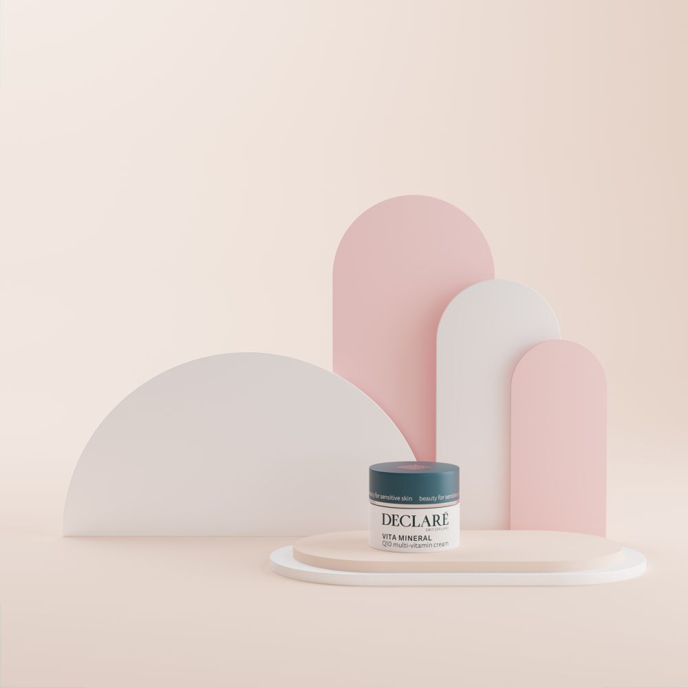 Creme-Tiegel auf Podest. DECLARÉ Vita Mineral Q10 Multi-Vitamin Creme. Hintergrund mit Formen.