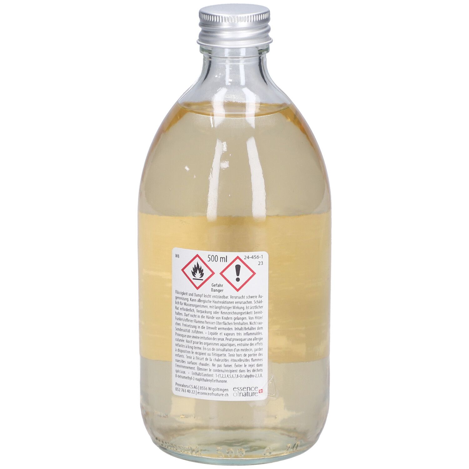 Glasflasche mit silbernem Deckel. Rückseite mit Etikett und Warnsymbolen. Flüssigkeit gelblich.
