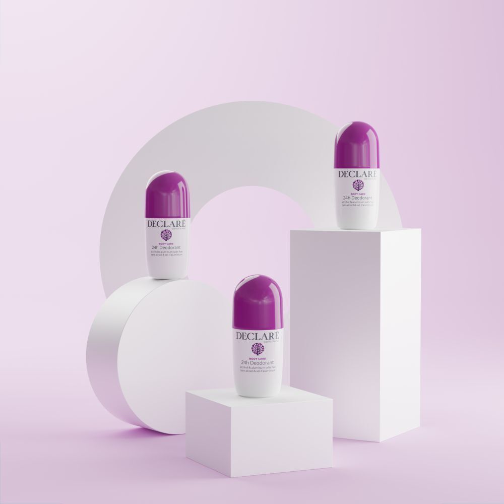 Drei Roll-on-Deos auf Podesten. Weißes Gehäuse, lila Kappe. DECLARÉ, 24h Deodorant. Hintergrund: weiße Formen, rosa Fläche.