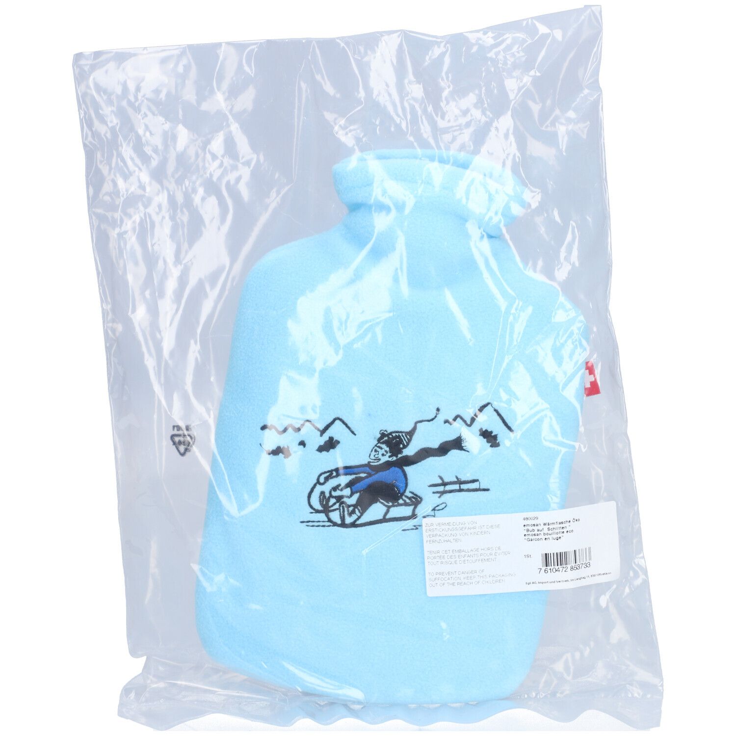 Bouillotte bleue claire dans un emballage plastique. Motif : garçon en luge. Étiquette avec texte et code-barres.