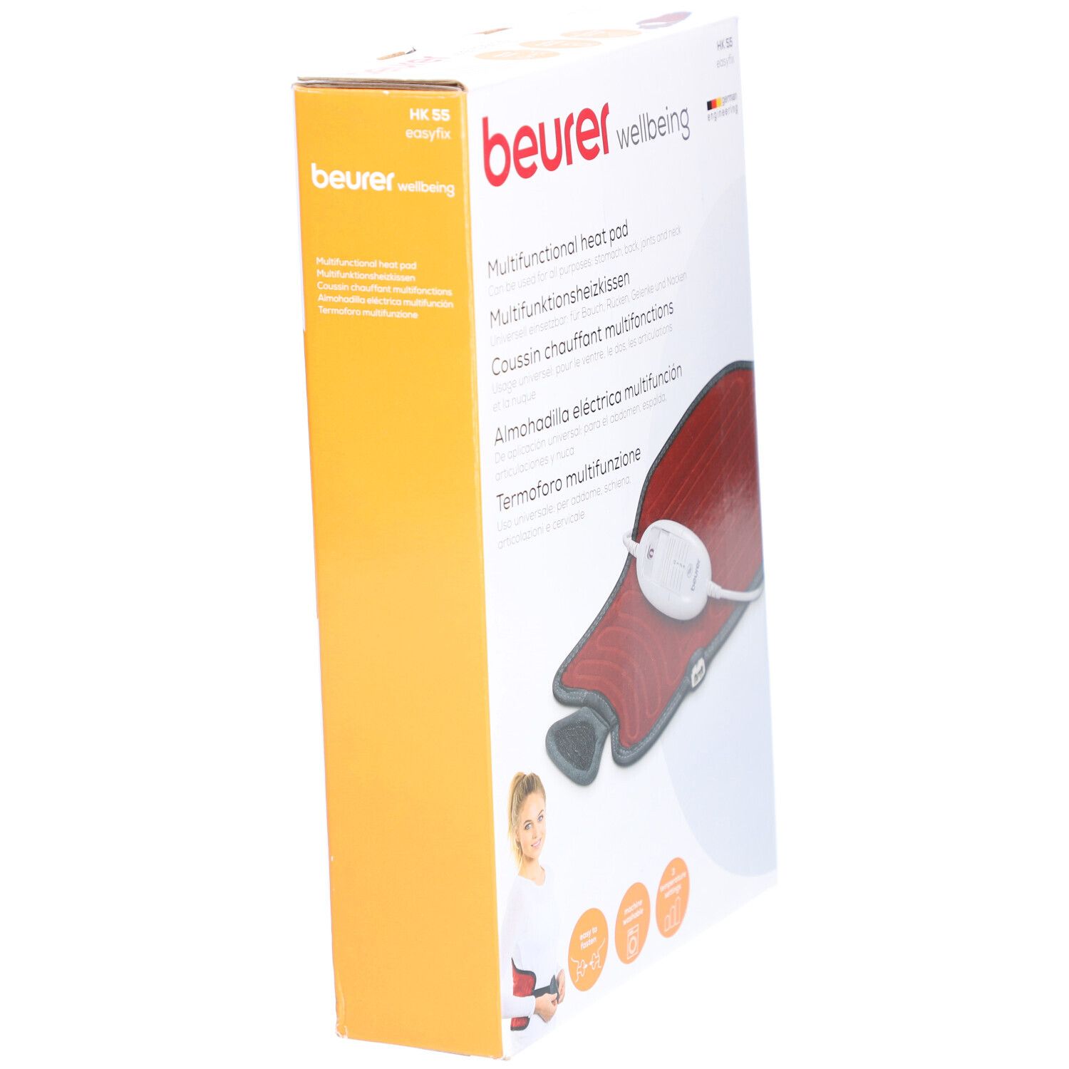 Verpackung, schräg. Heizkissen teilweise sichtbar. Rotes Kissen, grauer Rand, weißes Bedienelement. Marke: beurer.