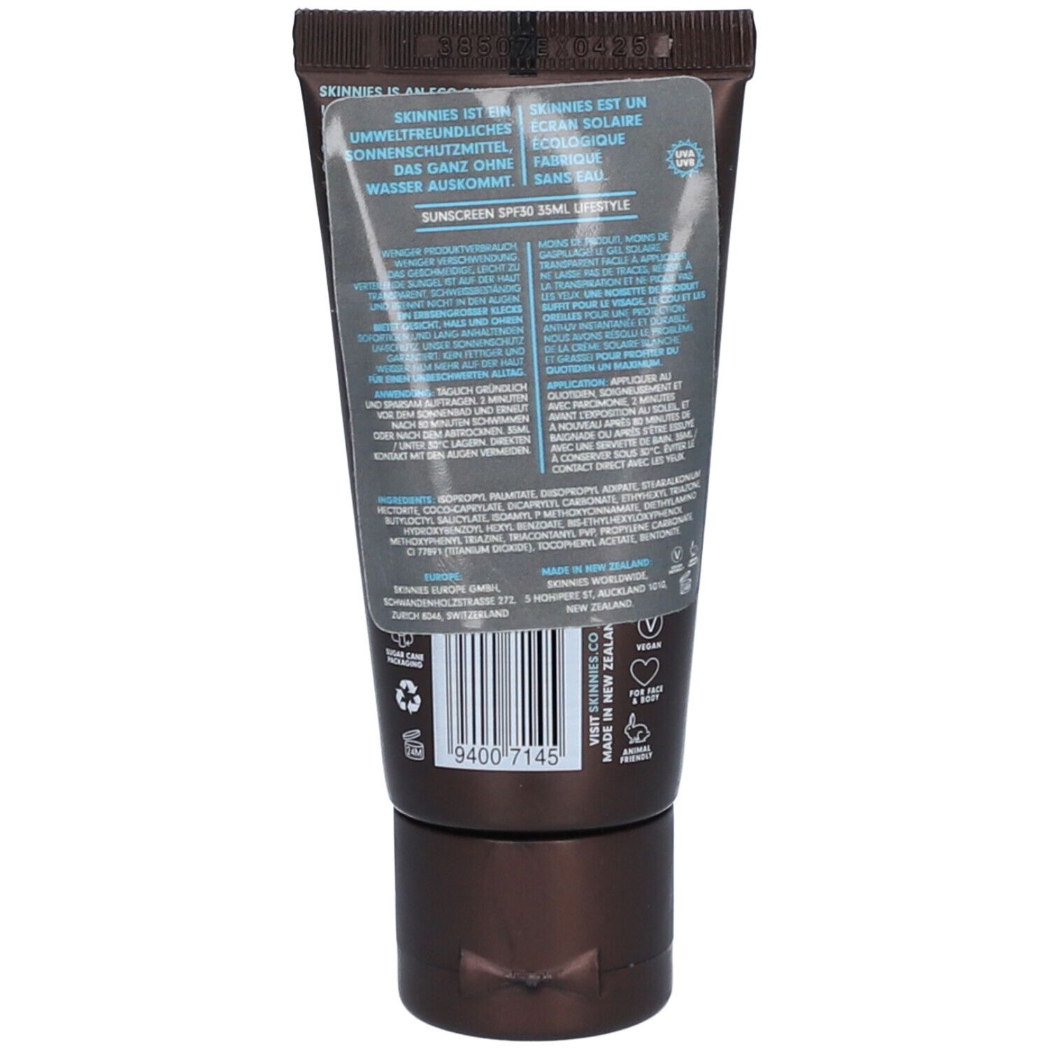 Rückseite der braunen Tube SKINNIES Sonnengel. Text und Barcode sichtbar. Transparenter Aufkleber mit Text.