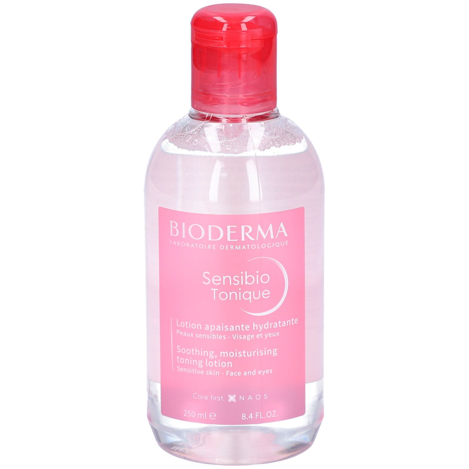 Klare Flasche mit rosa Etikett. BIODERMA Sensibio Tonique. Beruhigende, feuchtigkeitsspendende Gesichtslotion. Roter Deckel.