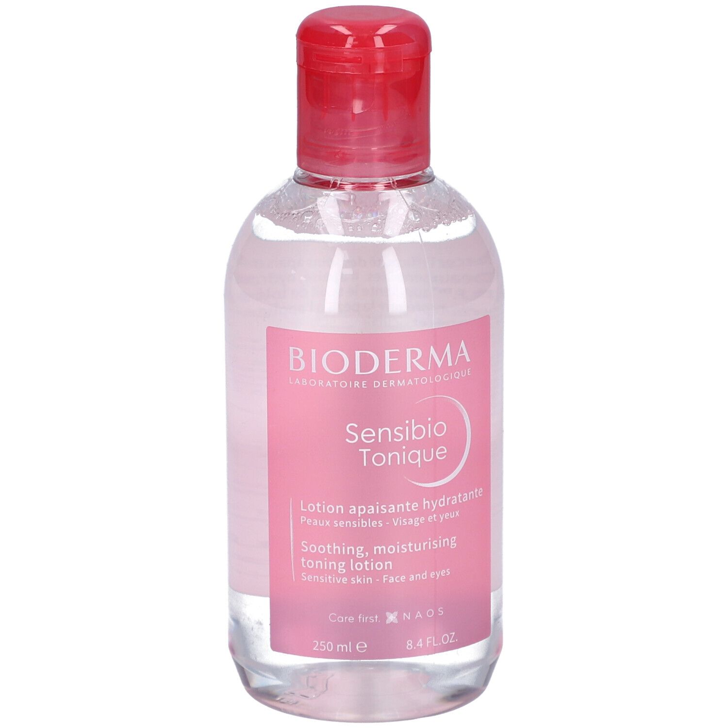 Klare Flasche mit rosa Etikett. BIODERMA Sensibio Tonique. Beruhigende, feuchtigkeitsspendende Gesichtslotion. Roter Deckel.