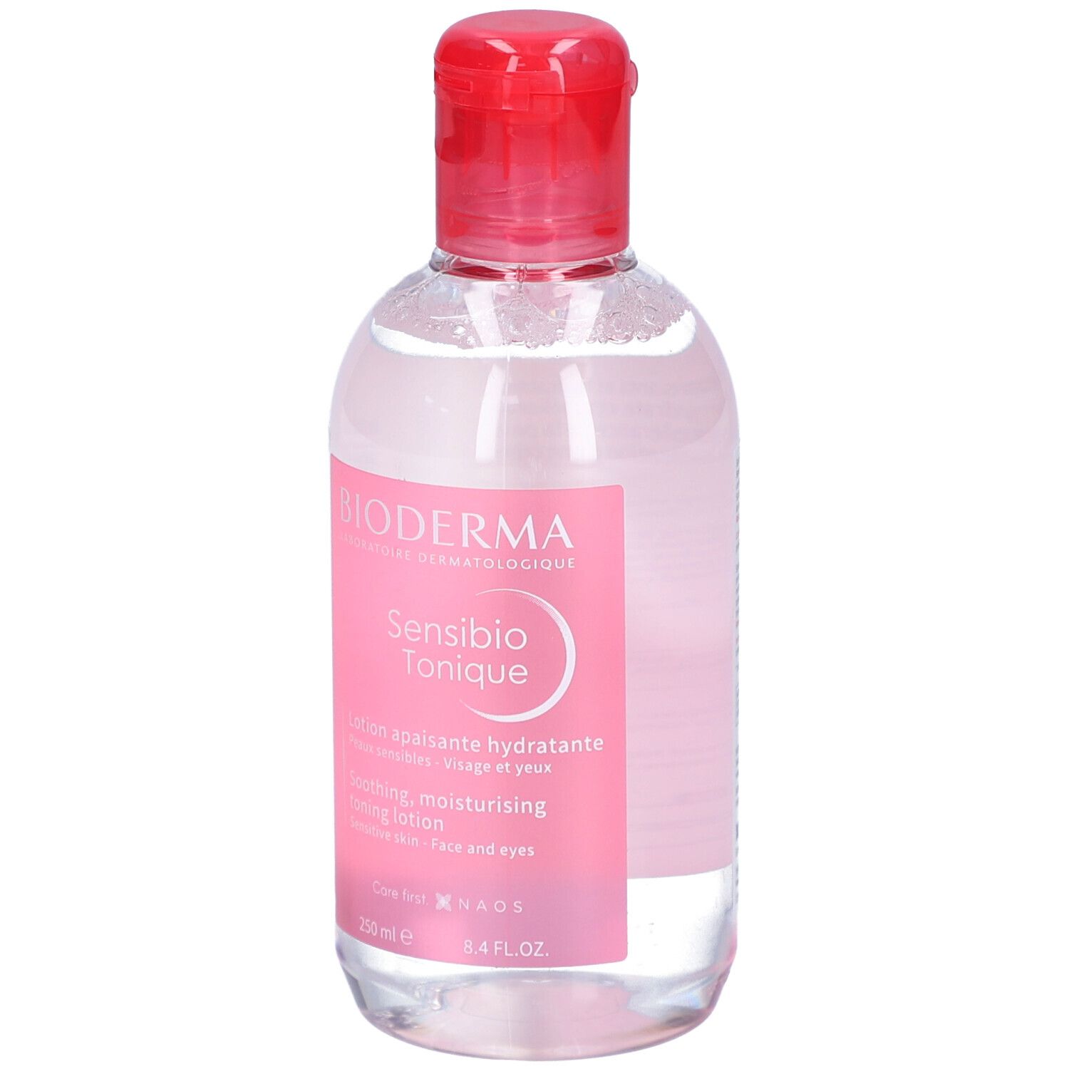 Klare Flasche mit rosa Etikett. BIODERMA Sensibio Tonique. Beruhigende, feuchtigkeitsspendende Gesichtslotion. Roter Deckel.