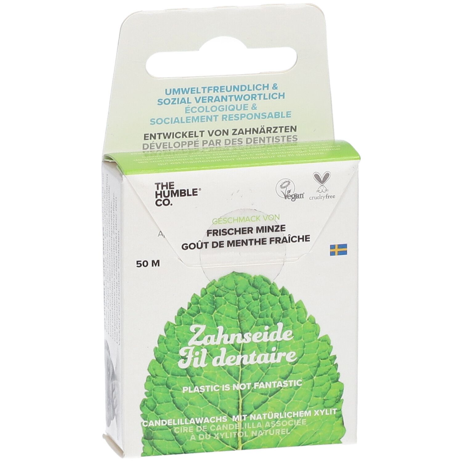 Zahnseide-Verpackung, leicht schräg. Text: Frischer Minze, Zahnseide, Plastic is not fantastic. Vegan-Siegel. Schwedische Flagge.
