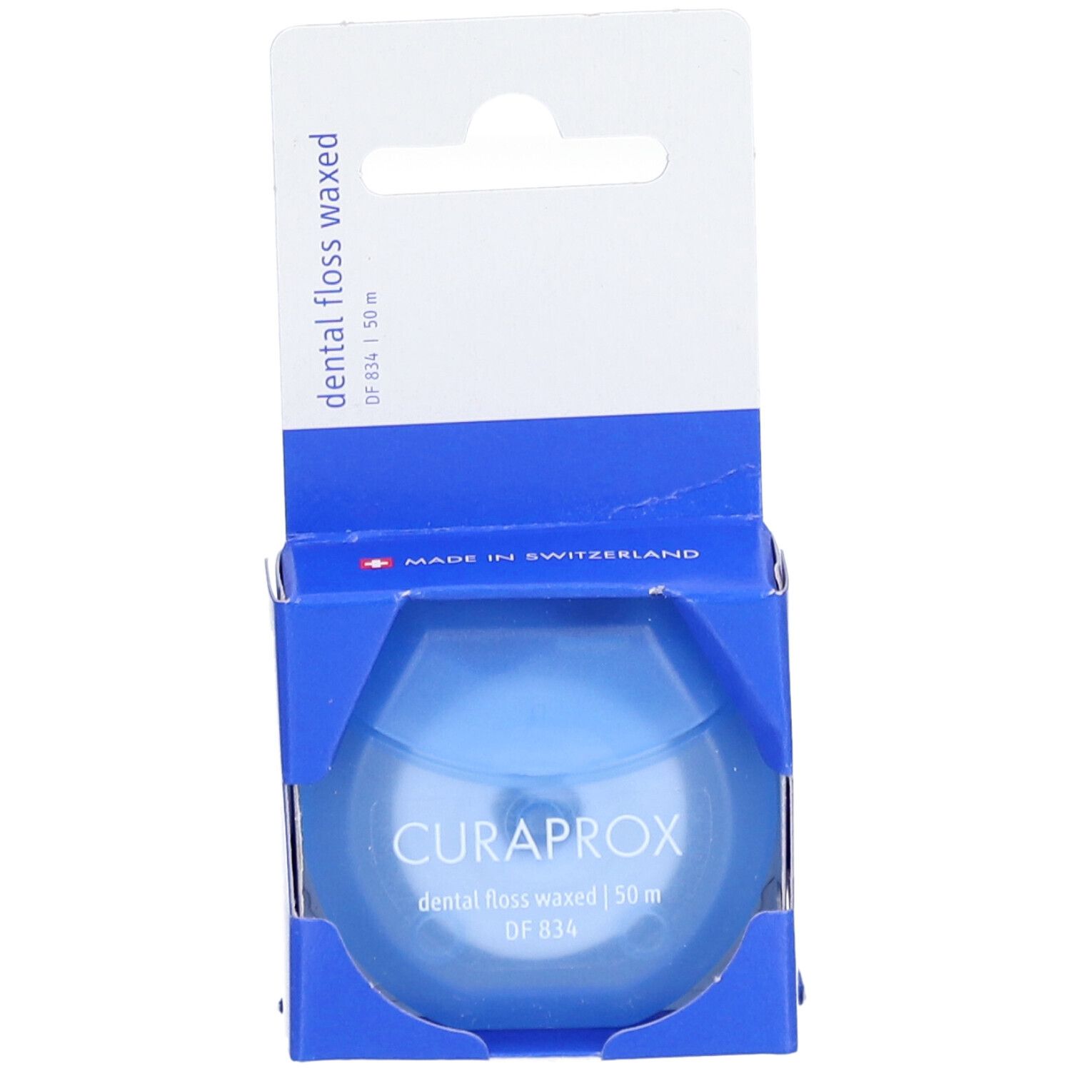 Fil dentaire dans un emballage bleu. Marque CURAPROX, 50 m, ciré.