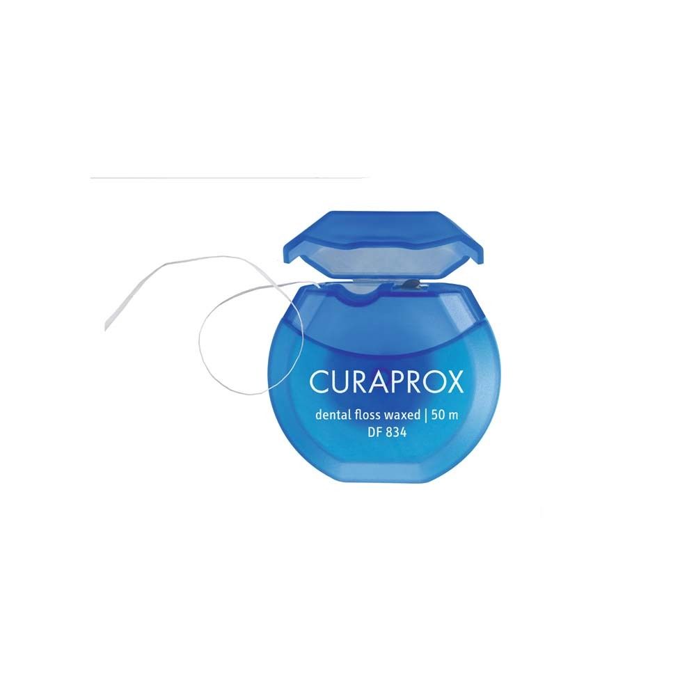 Blaue Zahnseide-Spule mit geöffnetem Deckel. Marke CURAPROX, Schriftzug "dental floss waxed".